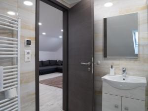 a bathroom with a sink and a mirror at Andoravendégház - Villány in Villány