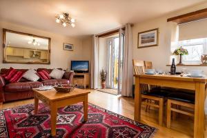ein Wohnzimmer mit einem Sofa und einem Tisch in der Unterkunft Tregarnedd Cottage in Llangefni