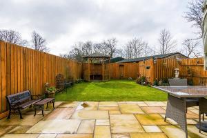 a backyard with a wooden fence and a table at Tregarnedd Cottage in Llangefni