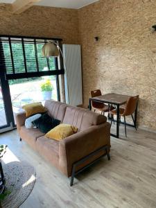 uma sala de estar com um sofá e uma mesa em Le cabanon em Houffalize