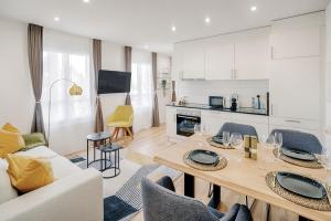 cocina y sala de estar con mesa y sillas en EH Apartments Jupiter, en St. Gallen