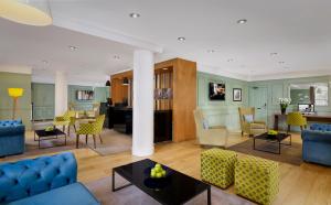 a living room with blue couches and a table at Citadines South Kensington London in London