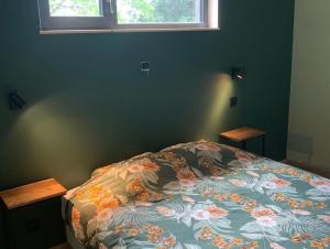 Le cabanon في هوفاليز: غرفة نوم مع سرير مع لحاف من الزهور ونافذة