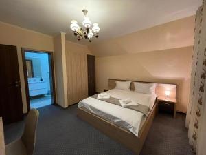 a bedroom with a bed and a chandelier at Casa Iulian in Cavnic