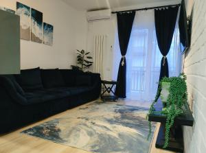 ein Wohnzimmer mit einem schwarzen Sofa und einem Teppich in der Unterkunft Amira Apartament in Constanţa