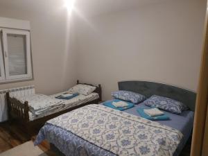a bedroom with two beds and a window at Apartman Dakovic in Zlatište
