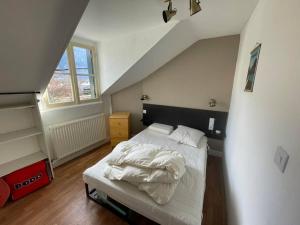 sypialnia z łóżkiem z białą pościelą w obiekcie Appartement T2 w mieście Luchon