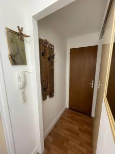 korytarz z drzwiami i telefonem na ścianie w obiekcie Appartement T2 w mieście Luchon