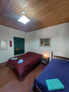 1 dormitorio con 2 camas y techo de madera en Postales del Tiempo en Tilcara