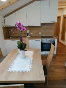 una cocina con una mesa de madera con un jarrón de flores. en Gspoi-Hof, en Laion