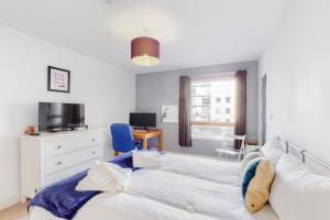 een slaapkamer met een bed, een bureau en een televisie bij Lovely 1 bed apartment in Streatham in Londen