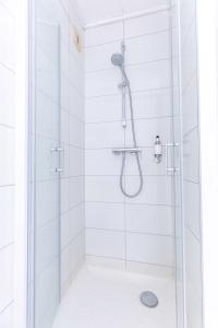 W łazience znajduje się prysznic ze szklanymi drzwiami. w obiekcie Dav'hotel Jaude w mieście Clermont-Ferrand