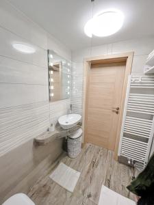 a white bathroom with a sink and a toilet at Apartments Sole in Podčetrtek