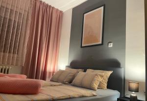 a bedroom with a bed with pink curtains at Apartman Tara Sombor in Sombor