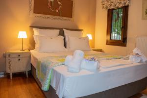 a bedroom with a large bed with white sheets and pillows at Sofia's House in Paleo Tsifliki