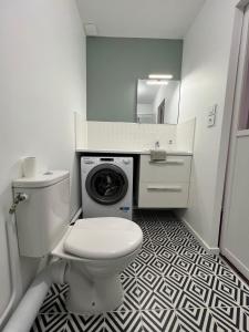 La salle de bains est pourvue de toilettes et d'un lave-linge. dans l'établissement Appartement Cosy - Deux pièces - Hyper centre, à Auxerre
