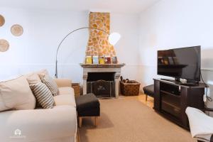 uma sala de estar com um sofá, uma televisão e uma lareira em Puerto Raval - 5 Bedrooms - BBQ & Garden em Santa Cruz