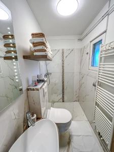 a white bathroom with a toilet and a sink at Apartments Sole in Podčetrtek