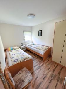 a room with two beds and a chair in it at Apartments Sole in Podčetrtek
