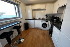 cocina con lavadora y ventana en River View Apartment - Central Dundee - Free Private Parking - Sky & TNT Sports - Lift Access - Superfast WIFI - Quiet Neighbourhood - 2 Bathrooms - Amazing Views - Balcony & Courtyard - Long Stays Welcome, en Dundee