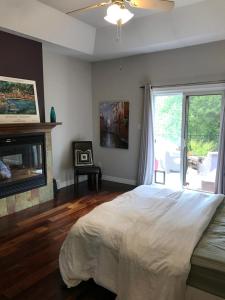 a bedroom with a bed and a fireplace and a window at Cozy Luxury on the Thames in Ontario! in London