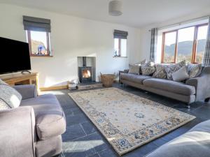 a living room with a couch and a fireplace at Cwmwr in Pen-y-bont-fawr