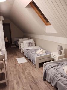 a attic room with three beds and a table at GuestHouse III in Lesko