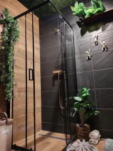 a shower in a room with a black wall at GuestHouse III in Lesko
