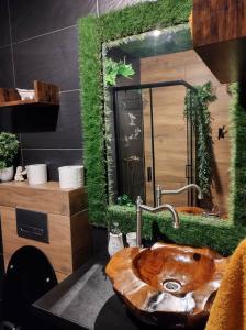 a bathroom with a wooden sink and a mirror at GuestHouse III in Lesko