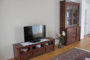 a living room with a flat screen tv and a entertainment center at Apartment Velden - Angelika Berginz in Velden am Wörthersee