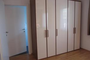 Pokój z białymi szafkami i szklanymi drzwiami w obiekcie Apartment Velden - Angelika Berginz w mieście Velden am Wörthersee