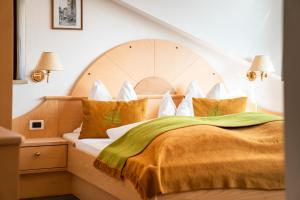 a bedroom with a large bed with a wooden headboard at Residence Innerfarmerhof in Tirolo