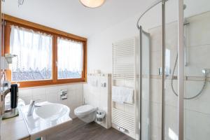 a bathroom with a toilet and a sink and a shower at Residence Innerfarmerhof in Tirolo +71 photos