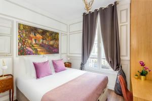 - une chambre avec un lit doté d'oreillers violets et d'un tableau dans l'établissement Luxury 5 Bedrooms 3 Bathrooms Apartment - Opera, à Paris