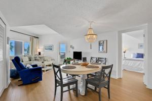 uma sala de jantar e sala de estar com mesa e cadeiras em Sandcastle Villas 215-216 em Fernandina Beach