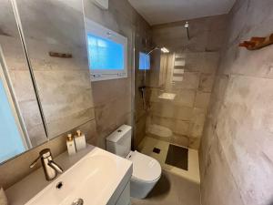 La salle de bains est pourvue d'un lavabo blanc et de toilettes. dans l'établissement Casa Malacitano, Caminito del Rey, à Valle de Abdalagís