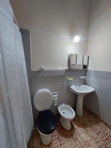 a bathroom with a toilet and a sink at Postales del Tiempo in Tilcara