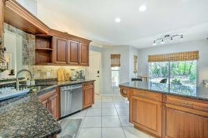 a large kitchen with wooden cabinets and a large island at Pet-Friendly Central Florida Home with Pool! in Lake Mary