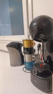 a coffee maker with two cups on top of it at Agréable T2 près des plages avec parking in Arcangues