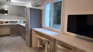 une cuisine avec un comptoir avec des chaises et une grande fenêtre dans l'établissement Agréable T2 près des plages avec parking, à Arcangues