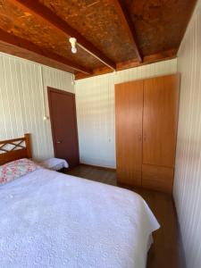 een slaapkamer met een bed en een houten kast bij Cabaña independiente a 5 minutos del centro in Valdivia