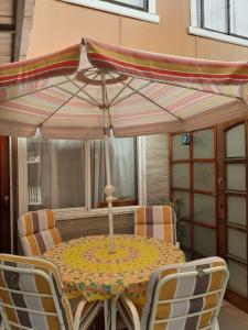 een tafel en stoelen met een parasol op een patio bij Cabaña independiente a 5 minutos del centro in Valdivia