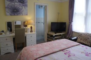 a bedroom with a desk and a bed and a deskicterictericterswersswers at Amazon Guest House in Oxford