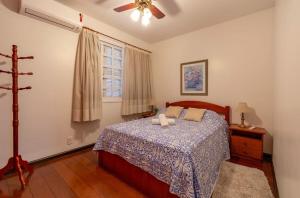 sypialnia z łóżkiem i wentylatorem sufitowym w obiekcie Rosa Edifício Saint Moritz w mieście Gramado