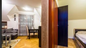 une chambre avec un lit et un salon avec une table dans l'établissement Apartman Adzic, à Zlatibor