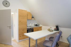 eine Küche mit einem weißen Tisch und 2 Stühlen in der Unterkunft Exklusives Ferienapartment in der Papenburger Stadtmitte in Papenburg