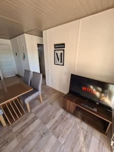 Monte Aromas في رولدان: غرفة معيشة مع طاولة وتلفزيون وطاولة وكراسي
