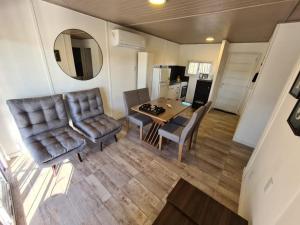 een woonkamer met een tafel, stoelen en een spiegel bij Monte Aromas in Roldán