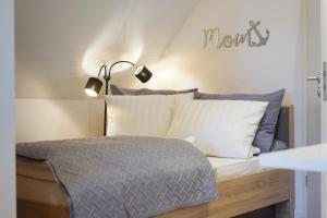 1 dormitorio con 1 cama con lámpara y almohadas en Exklusives Ferienapartment in der Papenburger Stadtmitte, en Papenburg
