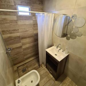 ein Badezimmer mit einem Waschbecken, einem WC und einem Spiegel in der Unterkunft Monte Aromas in Roldán